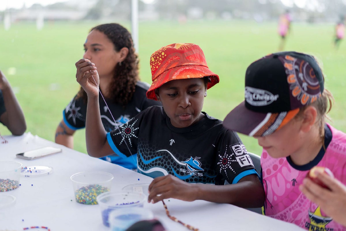 Children wearing Deadly Choices shirts and hates sitting at a table.